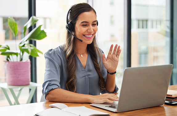 Customer help service person working on laptop smiling