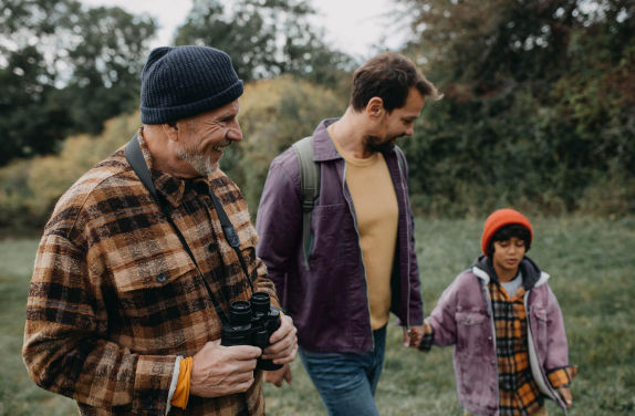 Grandfather faher and son walking in a field