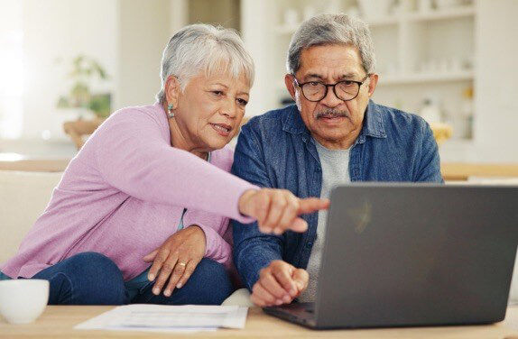 Elderly couple looking at the laptop